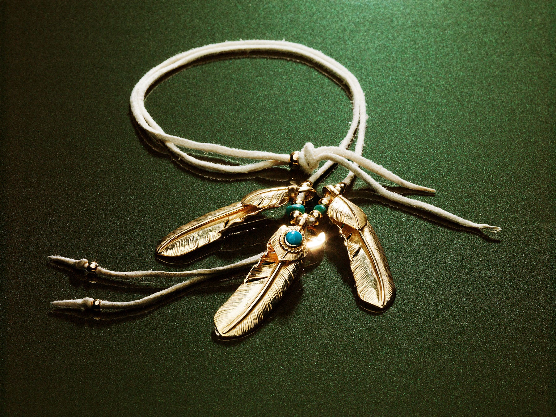 Goro's gold feathers on deerskin cord — Ginza Silver